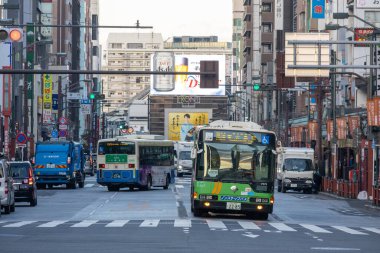 Tokyo, Japonya - 16 Aralık 2025: Yerel banliyö otobüsü Asakusa, Tokyo 'da caddede seyahat ediyor. Otobüsler boşlukları doldurur, özellikle belirli yerel alanlar, havaalanı aktarımları ve şehirlerarası seyahat için.