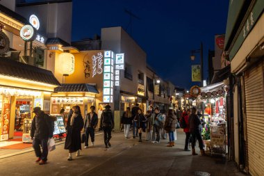Kamakura, Japonya-17 Aralık 2025: Komachi-dori Caddesi, Kamakura, Japonya. Komachi, kırmızı torii kapısı ile işaretlenmiş dar ve yayalara ait bir alışveriş merkezidir.
