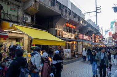 Tokyo, Japonya - 17 Aralık 2025: Ameyoko alışveriş caddesi Tokyo 'nun kalbinde yer almaktadır. Demiryolu hattının altındaki bu işlek pazar caddesinde 400 'den fazla dükkan var..