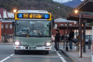 Kawaguchiko, Japonya- 21 Aralık 2025: Kawaguchiko gezi otobüsü Japonya 'daki istasyondan yolcu alıyor. Otobüs servisi Dağ 'ı keşfetmek için yararlıdır. Fuji manzarası ve Kawaguchi Gölü.