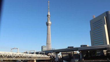 Tokyo, Japonya-15 Aralık 2025: Tokyo SkyTree 'nin Sumida Nehri üzerindeki mavi gökyüzü manzarası. Tokyo Skytree 'nin en önemli özelliği, Tokyo üzerinde muhteşem manzaralar sunan iki gözlem güvertesi.