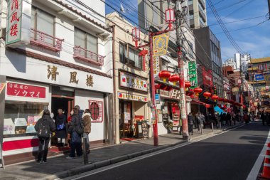 Yokohama, Japonya - 23 Aralık 2025: Yokohama, Japonya 'da Çin Mahallesi Vibrant Caddesi. Renkli kapılar ve bir dizi Çin yiyeceğiyle dolu enerjik sokaklar canlı ve hareketli bir atmosfer yaratıyor.