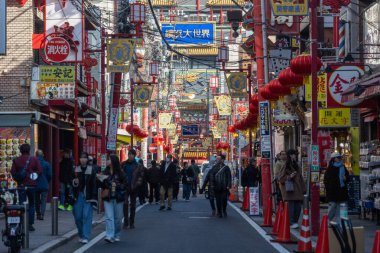 Yokohama, Japonya - 23 Aralık 2025: Yokohama, Japonya 'da Çin Mahallesi Vibrant Caddesi. Renkli kapılar ve bir dizi Çin yiyeceğiyle dolu enerjik sokaklar canlı ve hareketli bir atmosfer yaratıyor.