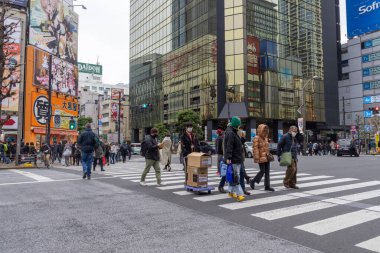 Tokyo, Japonya - 27 Aralık 2025: Tokyo, Akihabara 'da kalabalık caddeyi geçen büyük bir kalabalık. Akihabara, Japon anime, oyun ve elektronik kültürünün küresel merkezi olarak bilinir.
