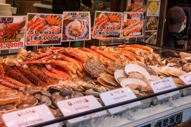 Tokyo, Japonya-28 Aralık 2025: Tokyo 'daki Tsukiji pazarında çeşitli deniz ürünleri satıldı. Tsukiji Marketi öncelikle perakende, restoran ve sokak yemeklerine odaklı canlı bir dış pazar.