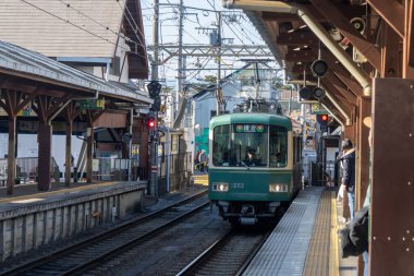Kamakura, Japonya-17 Aralık 2025: Enoshima treni istasyona yaklaşıyor. Enoden Hattı, Fujisawa ve Kamakura arasındaki mesafeyi kapsayan çok şirin bir tren hattıdır.