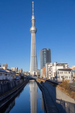 Tokyo, Japonya - 17 Aralık 2025: Tokyo Skytree 'nin inanılmaz yapısı tersine döndü ve nehre yansıdı. Gökyüzü ağacı 634 metre yüksekte süzülüyor ve Tokyo 'nun inanılmaz panoramik manzarasını veriyor.