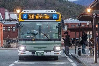 Kawaguchiko, Japonya- 21 Aralık 2025: Kawaguchiko gezi otobüsü Japonya 'daki istasyondan yolcu alıyor. Otobüs servisi Dağ 'ı keşfetmek için yararlıdır. Fuji manzarası ve Kawaguchi Gölü.