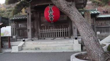 Kamakura, Japonya-17 Aralık 2025: Kırmızı fener Japonya 'nın Kamakura kentindeki Hasedera Tapınağı' nın giriş kapısında asılı. Kırmızı fener statüsünü gösteriyor ve tarihi bir kompleksin girişini gösteriyor.