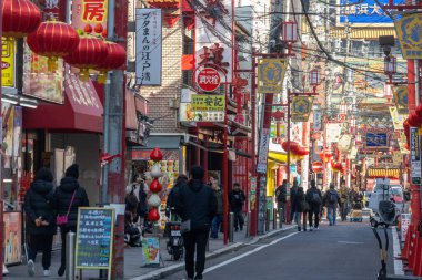 Yokohama, Japonya - 23 Aralık 2025: Yokohama, Japonya 'da Çin Mahallesi Vibrant Caddesi. Renkli kapılar ve bir dizi Çin yiyeceğiyle dolu enerjik sokaklar canlı ve hareketli bir atmosfer yaratıyor.