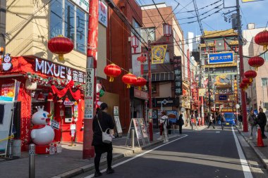 Yokohama, Japonya - 23 Aralık 2025: Yokohama, Japonya 'da Çin Mahallesi Vibrant Caddesi. Renkli kapılar ve bir dizi Çin yiyeceğiyle dolu enerjik sokaklar canlı ve hareketli bir atmosfer yaratıyor.
