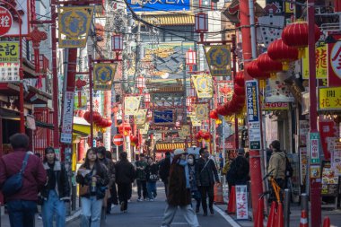 Yokohama, Japonya - 23 Aralık 2025: Yokohama, Japonya 'da Çin Mahallesi Vibrant Caddesi. Renkli kapılar ve bir dizi Çin yiyeceğiyle dolu enerjik sokaklar canlı ve hareketli bir atmosfer yaratıyor.