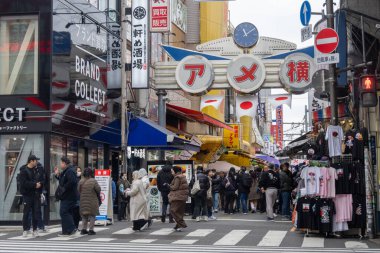 Tokyo, Japonya - 27 Aralık 2025: Tokyo, Japonya 'da Ueno Ameyoko canlı pazar sahnesi. Yükseltilmiş demiryolu hattının altında bir mağaza koleksiyonu.