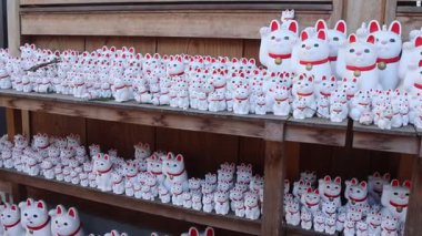 Tokyo, Japonya - 26 Aralık 2025: Tokyo 'nun Setagaya semtindeki Gotokuji Tapınağı' nda bulunan kedi veya maneki-neko figürleri. Şans, servet ve mutluluk getirdiğine inanılır.