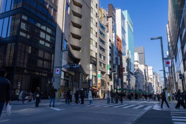 Tokyo, Japonya-28 Aralık 2025: Ginza ana caddesi, Chuo Dori, hafta sonları yayalara özel bir bölge haline geliyor. Lüks mağazalarla dolu hareketli, arabasız bir alışveriş alanı yaratmak.