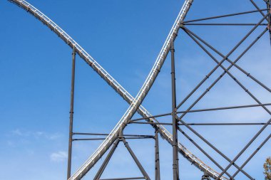 Mavi gökyüzü ile çelik hız treni pisti. Lunaparktaki eğlence parkında hız treninin çelik pist yapısı