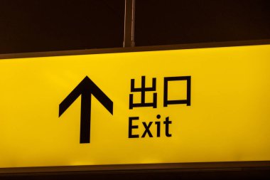 İngilizce ve Çince yazılı sarı çıkış işareti. Çıkış işareti.