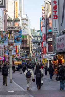 Tokyo, Japonya - 16 Aralık 2025: İnsanlar Tokyo 'nun enerjisinin gerçekten canlandığı Shibuya Center-Gai' yi ziyaret ediyor. Neon ışıkları, modaya uygun dükkanlar, atari salonları ve sonsuz yiyecek seçenekleriyle doluydu.