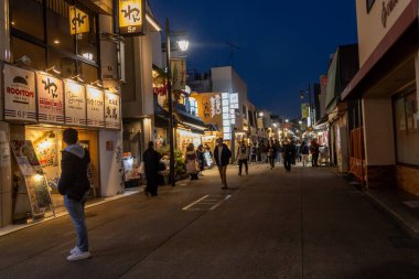 Kamakura, Japonya-17 Aralık 2025: Komachi-dori Caddesi, Kamakura, Japonya. Komachi, kırmızı torii kapısı ile işaretlenmiş dar ve yayalara ait bir alışveriş merkezidir.
