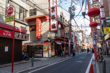 Yokohama, Japonya - 23 Aralık 2025: Yokohama, Japonya 'da Çin Mahallesi Vibrant Caddesi. Renkli kapılar ve bir dizi Çin yiyeceğiyle dolu enerjik sokaklar canlı ve hareketli bir atmosfer yaratıyor.