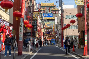 Yokohama, Japonya - 23 Aralık 2025: Yokohama, Japonya 'da Çin Mahallesi Vibrant Caddesi. Renkli kapılar ve bir dizi Çin yiyeceğiyle dolu enerjik sokaklar canlı ve hareketli bir atmosfer yaratıyor.