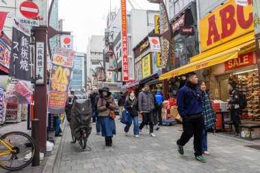 Tokyo, Japonya - 27 Aralık 2025: Tokyo, Japonya 'da Ueno Ameyoko canlı pazar sahnesi. Yükseltilmiş demiryolu hattının altında bir mağaza koleksiyonu.