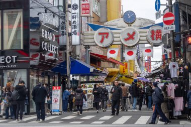 Tokyo, Japonya - 27 Aralık 2025: Tokyo, Japonya 'da Ueno Ameyoko canlı pazar sahnesi. Yükseltilmiş demiryolu hattının altında bir mağaza koleksiyonu.