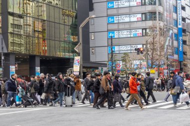 Tokyo, Japonya - 27 Aralık 2025: Tokyo, Akihabara 'da kalabalık caddeyi geçen büyük bir kalabalık. Akihabara, Japon anime, oyun ve elektronik kültürünün küresel merkezi olarak bilinir.
