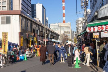 Tokyo, Japonya-28 Aralık 2025: Tokyo 'daki Tsukiji Dış Pazarı' nı ziyaret eden turistler. Pazar, özellikle deniz ürünleri aşıkları olmak üzere aşçılık deneyimleri arayan ziyaretçiler için hareketli bir merkez olmaya devam ediyor.