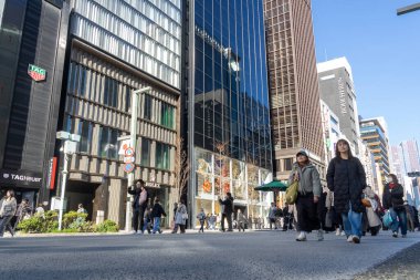 Tokyo, Japonya-28 Aralık 2025: Ginza ana caddesi, Chuo Dori, hafta sonları yayalara özel bir bölge haline geliyor. Lüks mağazalarla dolu hareketli, arabasız bir alışveriş alanı yaratmak.