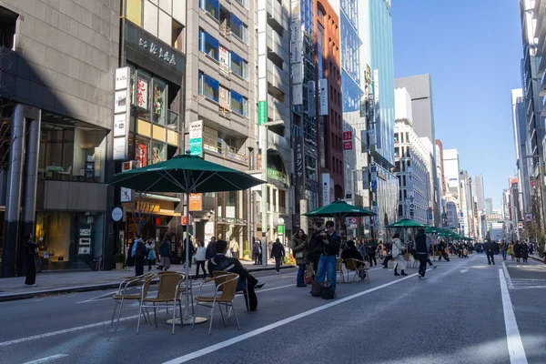 Tokyo, Japonya-28 Aralık 2025: Ginza ana caddesi, Chuo Dori, hafta sonları yayalara özel bir bölge haline geliyor. Lüks mağazalarla dolu hareketli, arabasız bir alışveriş alanı yaratmak.