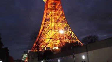 Tokyo, Japonya- 22 Aralık 2025: Tokyo Kulesi sıcak turuncu renkle aydınlanıyor. Dik durarak, şehir manzaralarını süpürüyor, özellikle de karanlık çöktüğünde, Tokyo 'yu sıcak ve büyüleyici bir şekilde aydınlatıyor.