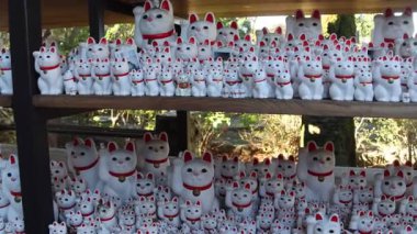 Tokyo, Japonya - 26 Aralık 2025: Tokyo 'nun Setagaya semtindeki Gotokuji Tapınağı' nda bulunan kedi veya maneki-neko figürleri. Şans, servet ve mutluluk getirdiğine inanılır.