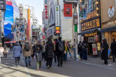 Tokyo, Japonya - 16 Aralık 2025: İnsanlar Tokyo 'nun enerjisinin gerçekten canlandığı Shibuya alışveriş alanını ziyaret ediyor. Neon ışıkları, modaya uygun dükkanlar, atari salonları ve sonsuz yiyecek seçenekleriyle doluydu.