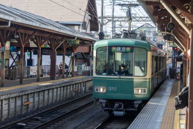 Kamakura, Japonya-17 Aralık 2025: Enoshima treni istasyona yaklaşıyor. Enoden Hattı, Fujisawa ve Kamakura arasındaki mesafeyi kapsayan çok şirin bir tren hattıdır.