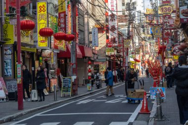 Yokohama, Japonya - 23 Aralık 2025: Yokohama, Japonya 'da Çin Mahallesi Vibrant Caddesi. Renkli kapılar ve bir dizi Çin yiyeceğiyle dolu enerjik sokaklar canlı ve hareketli bir atmosfer yaratıyor.