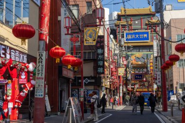 Yokohama, Japonya - 23 Aralık 2025: Yokohama, Japonya 'da Çin Mahallesi Vibrant Caddesi. Renkli kapılar ve bir dizi Çin yiyeceğiyle dolu enerjik sokaklar canlı ve hareketli bir atmosfer yaratıyor.