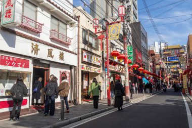 Yokohama, Japonya - 23 Aralık 2025: Yokohama, Japonya 'da Çin Mahallesi Vibrant Caddesi. Renkli kapılar ve bir dizi Çin yiyeceğiyle dolu enerjik sokaklar canlı ve hareketli bir atmosfer yaratıyor.