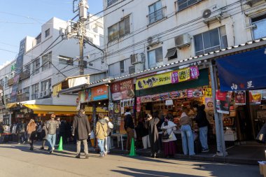 Tokyo, Japonya-28 Aralık 2025: Tokyo 'daki Tsukiji Dış Pazarı' nı ziyaret eden turistler. Pazar, özellikle deniz ürünleri aşıkları olmak üzere aşçılık deneyimleri arayan ziyaretçiler için hareketli bir merkez olmaya devam ediyor.