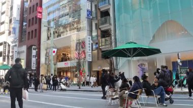 Tokyo, Japonya-28 Aralık 2025: Ginza ana caddesi, Chuo Dori, hafta sonları yayalara özel bir bölge haline geliyor. Lüks mağazalarla dolu hareketli, arabasız bir alışveriş alanı yaratmak.