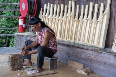 Kuching, Malezya - 27 Ocak 2026: İnsanlar Malezya 'nın Kuching kentindeki Sarawak Kültür Köyü' nde Orang Ulu Geleneksel Müzik Enstrümanını yapıyorlar. Bu, Orang Ulu toplumunun geleneksel bir lavtası.