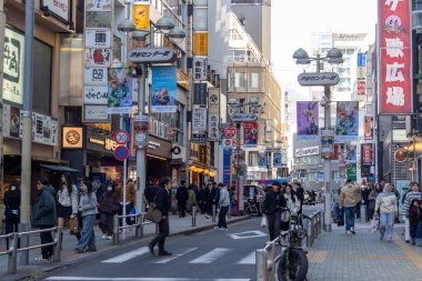 Tokyo, Japonya - 16 Aralık 2025: İnsanlar Tokyo 'nun enerjisinin gerçekten canlandığı Shibuya Center-Gai' yi ziyaret ediyor. Neon ışıkları, modaya uygun dükkanlar, atari salonları ve sonsuz yiyecek seçenekleriyle doluydu.
