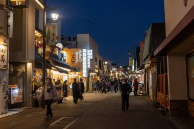 Kamakura, Japonya-17 Aralık 2025: Komachi-dori Caddesi, Kamakura, Japonya. Komachi, kırmızı torii kapısı ile işaretlenmiş dar ve yayalara ait bir alışveriş merkezidir.