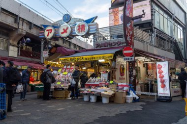 Tokyo, Japonya - 17 Aralık 2025: Ameyoko alışveriş caddesi Tokyo 'nun kalbinde yer almaktadır. Demiryolu hattının altındaki bu işlek pazar caddesinde 400 'den fazla dükkan var..