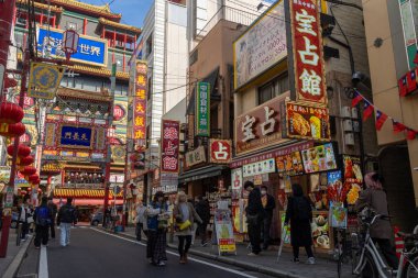 Yokohama, Japonya - 23 Aralık 2025: Yokohama, Japonya 'da Çin Mahallesi Vibrant Caddesi. Renkli kapılar ve bir dizi Çin yiyeceğiyle dolu enerjik sokaklar canlı ve hareketli bir atmosfer yaratıyor.