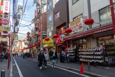 Yokohama, Japonya - 23 Aralık 2025: Yokohama, Japonya 'da Çin Mahallesi Vibrant Caddesi. Renkli kapılar ve bir dizi Çin yiyeceğiyle dolu enerjik sokaklar canlı ve hareketli bir atmosfer yaratıyor.
