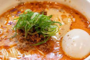 Japon stili Dan Noodle veya Tantanmen bir kasede servis edildi. Kremalı, fındıklı ve baharatlı bir Çin yemeği çeşidi. Zengin bir çorba içeriyor. Karmaşık ama doyurucu bir lezzet sunuyor.
