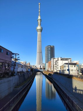 Tokyo, Japonya - 17 Aralık 2025: Mavi gökyüzü ile Tokyo Skytree 'nin inanılmaz yapısı. Gökyüzü ağacı 634 metre yüksekte süzülüyor ve Tokyo 'nun inanılmaz panoramik manzarasını veriyor.