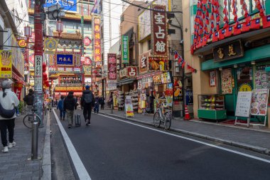 Yokohama, Japonya - 23 Aralık 2025: Yokohama, Japonya 'da Çin Mahallesi Vibrant Caddesi. Renkli kapılar ve bir dizi Çin yiyeceğiyle dolu enerjik sokaklar canlı ve hareketli bir atmosfer yaratıyor.