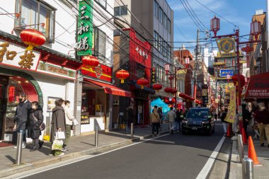 Yokohama, Japonya - 23 Aralık 2025: Yokohama, Japonya 'da Çin Mahallesi Vibrant Caddesi. Renkli kapılar ve bir dizi Çin yiyeceğiyle dolu enerjik sokaklar canlı ve hareketli bir atmosfer yaratıyor.